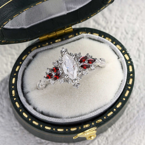 Gisthriel solitaire engagement ring with marquise moissanite and red gemstone accents in elegant jewelry box