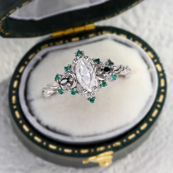 Wynriel three-stone engagement ring with marquise moissanite center and green side stones in elegant ring box