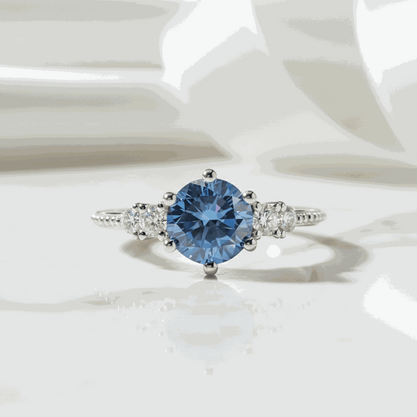 Gloraviel three-stone engagement ring with 1-carat round blue moissanite centerpiece and classic design