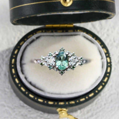 Dulawen three-stone engagement ring with oval sapphire and trillion moissanite side stones in elegant black velvet box