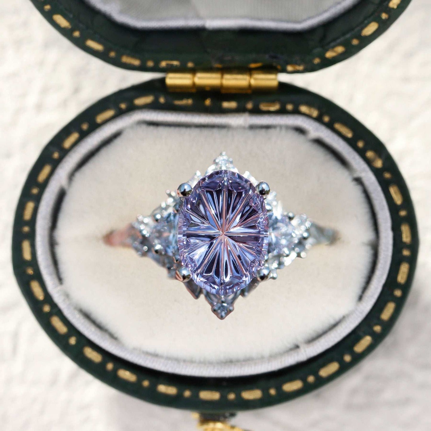 Ureswen three-stone engagement ring with oval sapphire and moissanite side stones in a velvet box