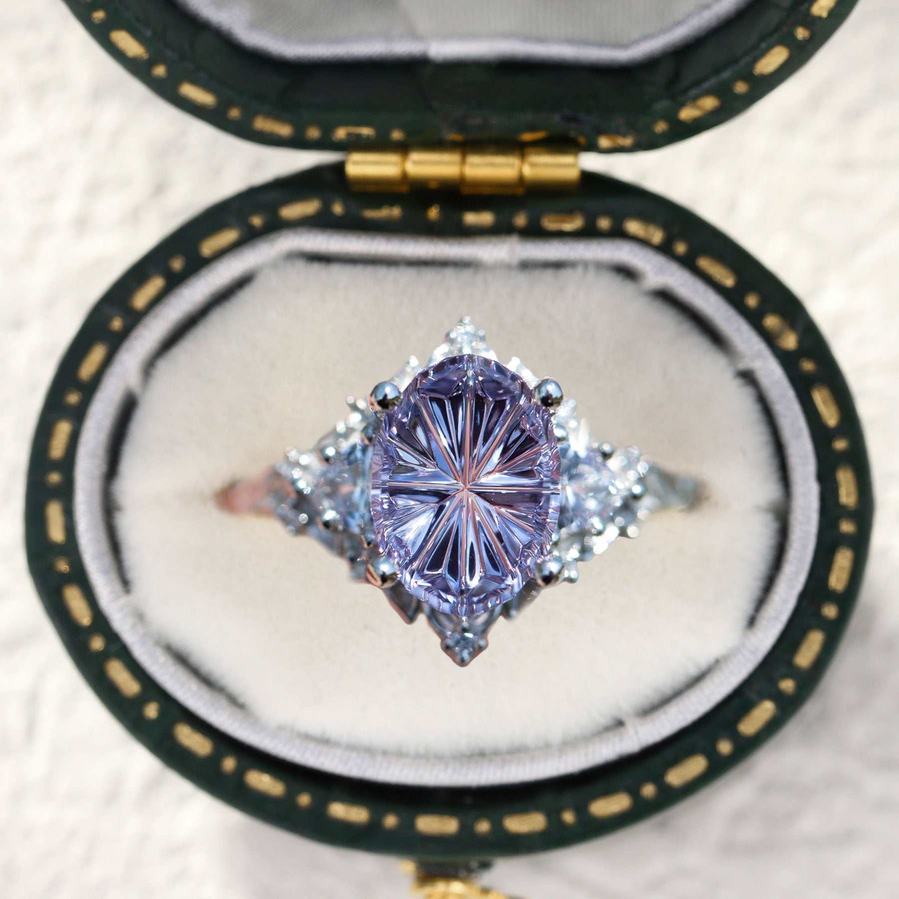Ureswen three-stone engagement ring with oval sapphire and moissanite side stones in a velvet box