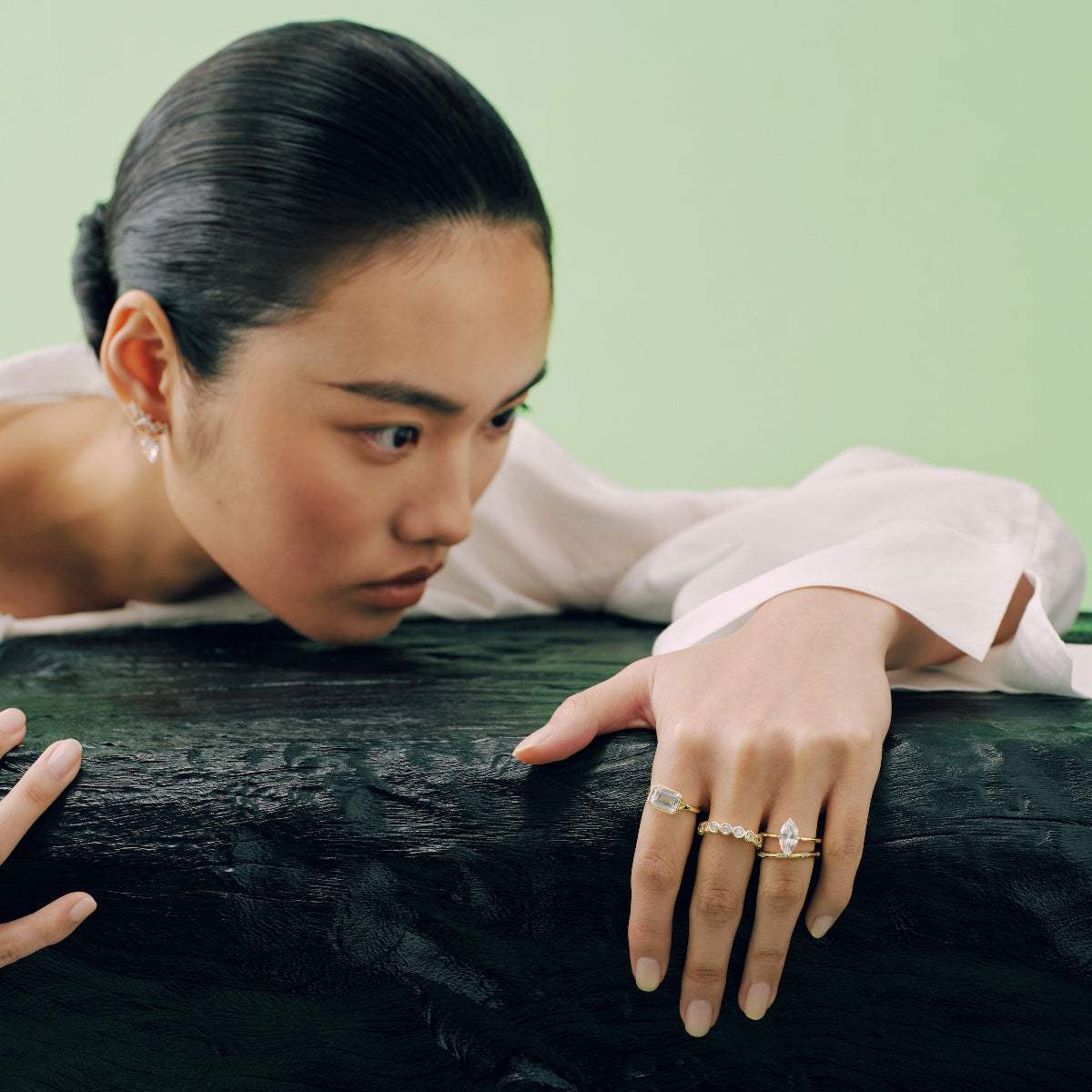 Woman showcasing Roen Ring Damariel with split shank and emerald-shaped moissanite stone on hand