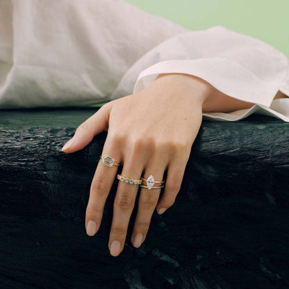 Close-up of hand wearing Damariel Roen Ring with emerald-shaped moissanite stone and split shank design