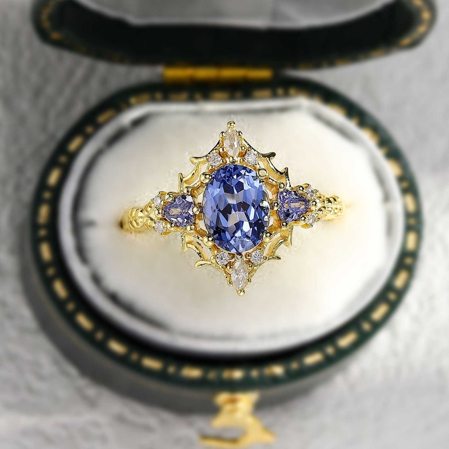 Corsaviel three-stone engagement ring with oval sapphire center and gold setting in vintage box