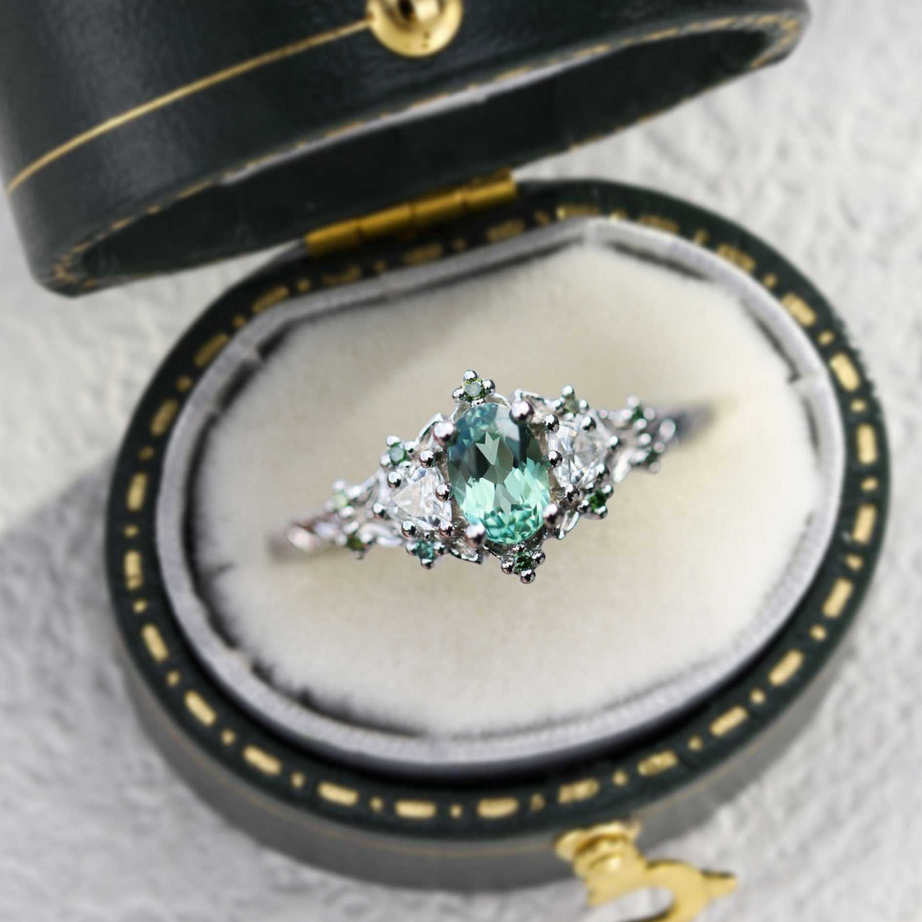 Dulawen three-stone engagement ring with oval sapphire and trillion moissanite side stones in elegant vintage box