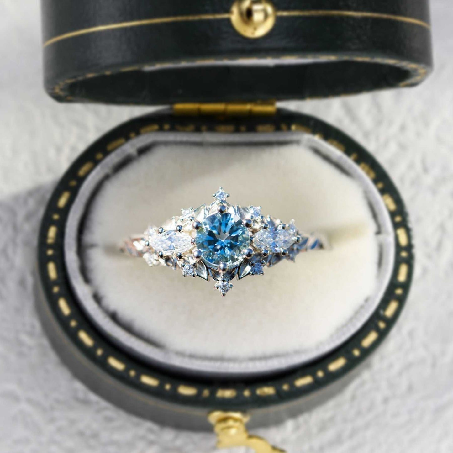 Nelawen three-stone engagement ring with 6mm aquamarine and marquise moissanite stones in black velvet box