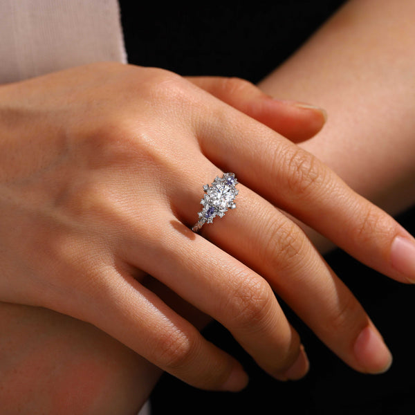 Rilaswen ring with round moissanite center stone and two accent stones on finger