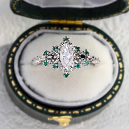 Wynriel three-stone marquise moissanite engagement ring with green accent stones in vintage box