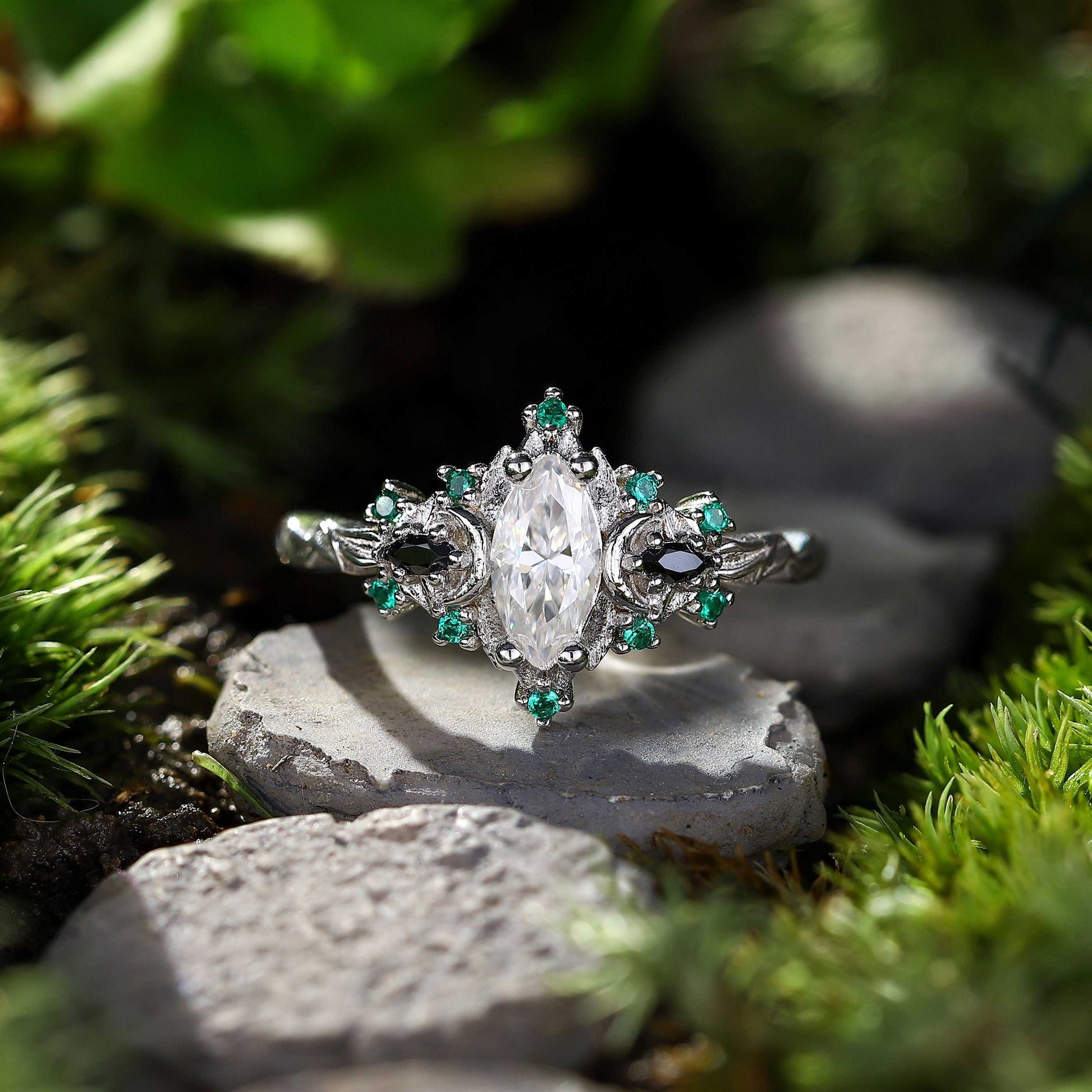 Wynriel three-stone engagement ring with marquise moissanite center and green gemstone accents in silver setting.