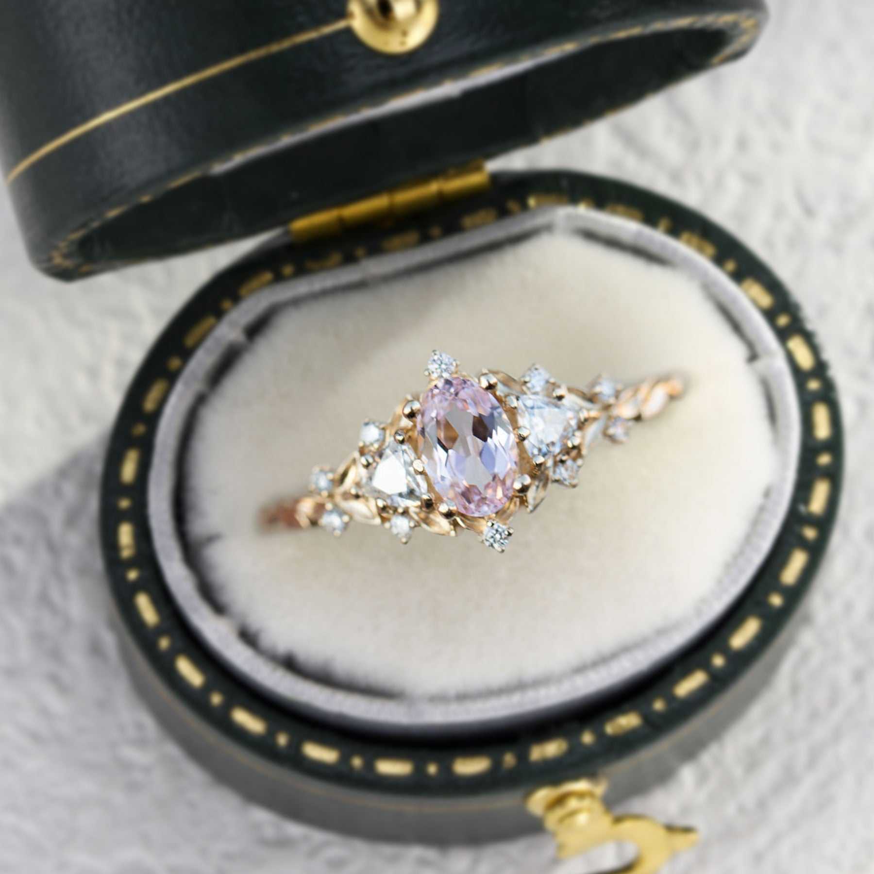Uthriel three-stone engagement ring with oval sapphire and moissanite side stones in a black velvet box