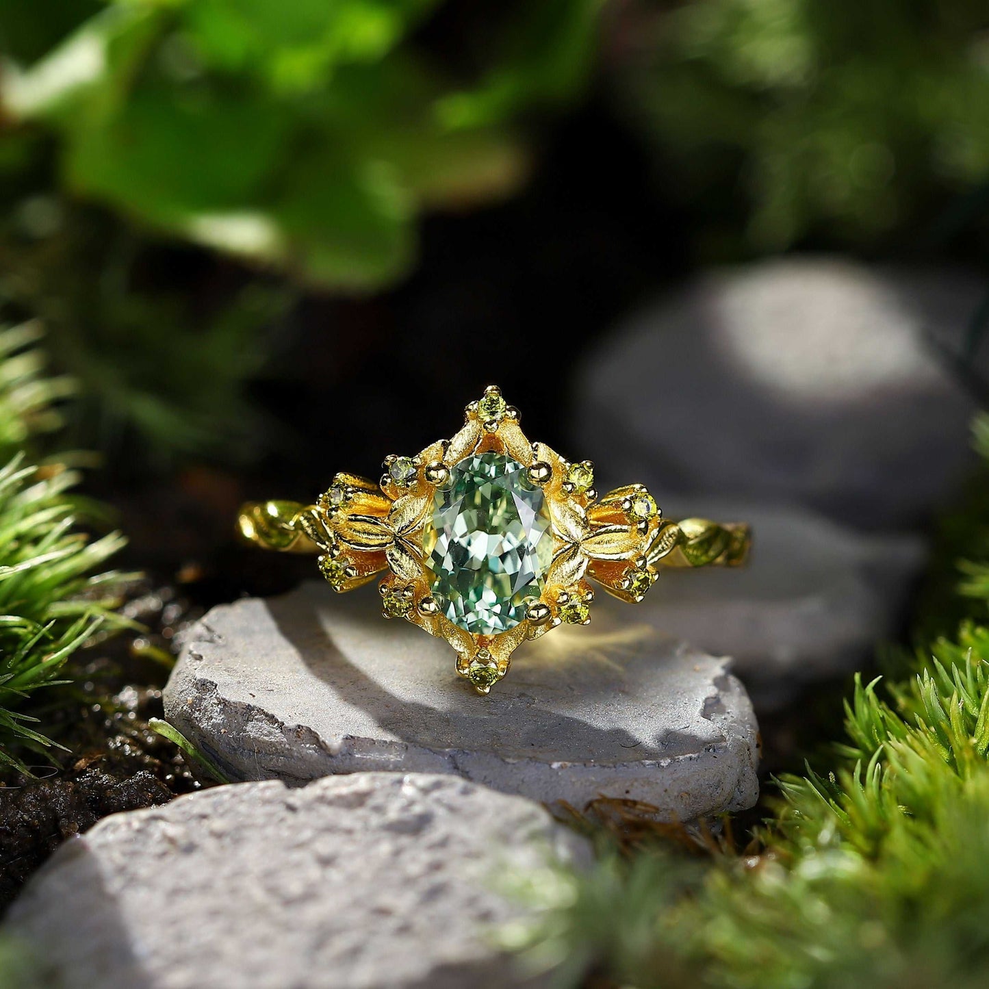 Xevoria solitaire engagement ring with oval sandstone center and gold floral accents on natural stone background