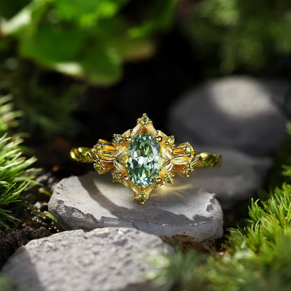Xevoria solitaire engagement ring with oval sandstone center and gold floral accents on natural stone background