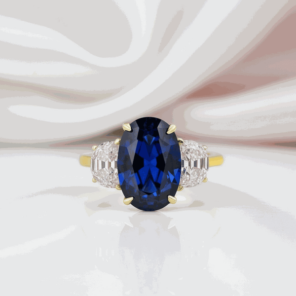 Quaeriel ring with 3.5 carat oval blue sapphire and two side diamonds on gold band