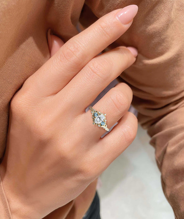 Vaelawen three-stone engagement ring with 4 ct oval moissanite center and two side stones on hand