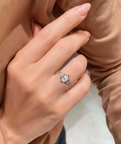 Belinor ring with pear-shaped moissanite center stone and delicate side stones on hand
