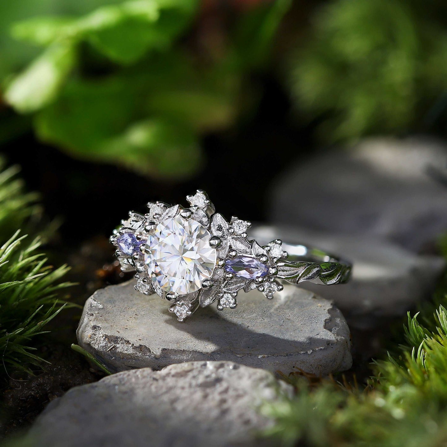 Rilaswen ring with round moissanite center stone and two smaller accent stones on nature background