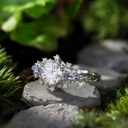 Rilaswen ring with round moissanite center stone and two smaller accent stones on nature background