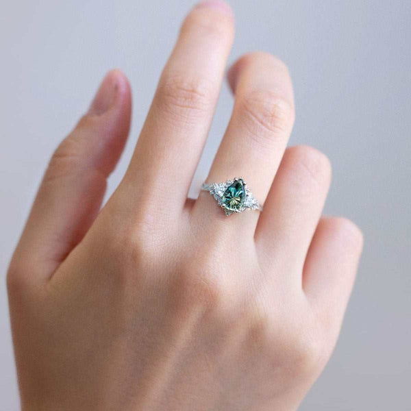 Garaniel solitaire engagement ring with pear-shaped sapphire and moissanite side stones on slender band