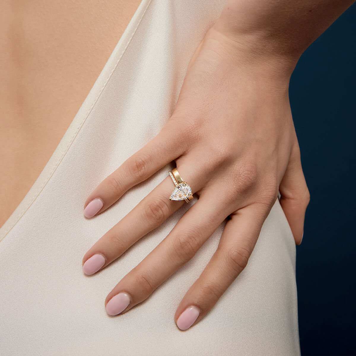 Kylariel pear-shaped moissanite solitaire engagement ring with half pavé and hidden halo on hand