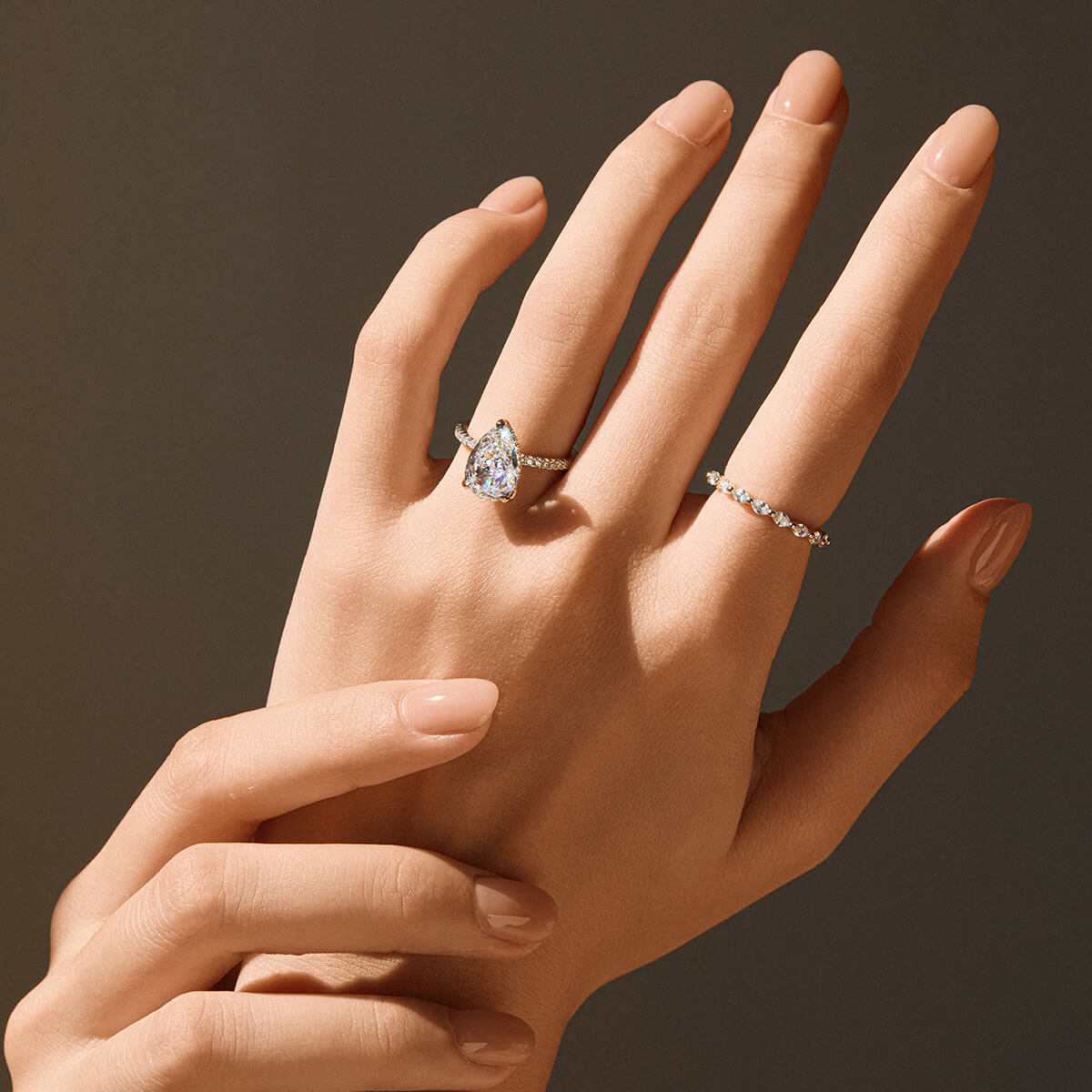 Kylariel solitaire engagement ring with pear-shaped moissanite and half pavé design on hand