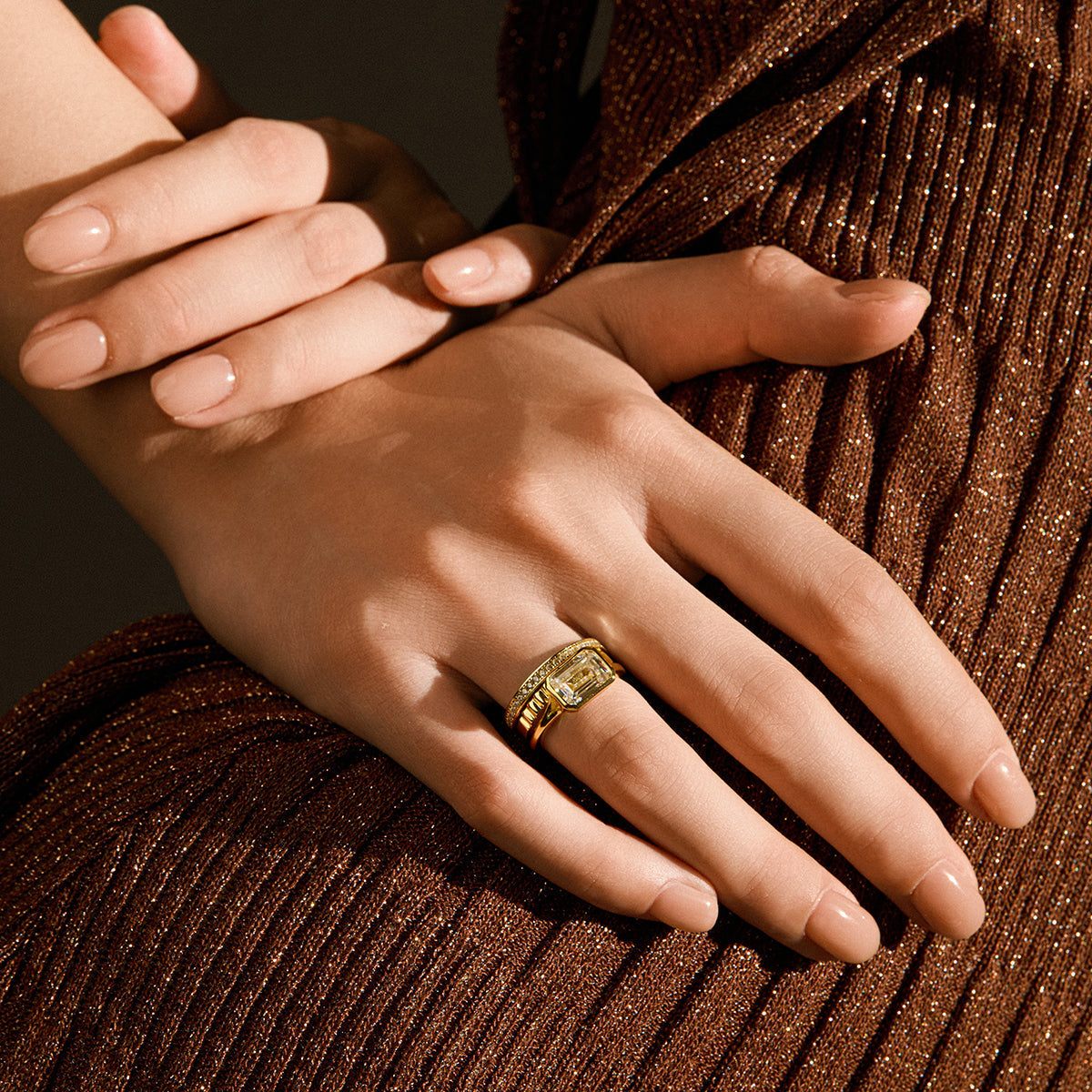 Close-up of hands wearing the Damariel Roen Ring with a split shank and emerald-shaped moissanite solitaire stone