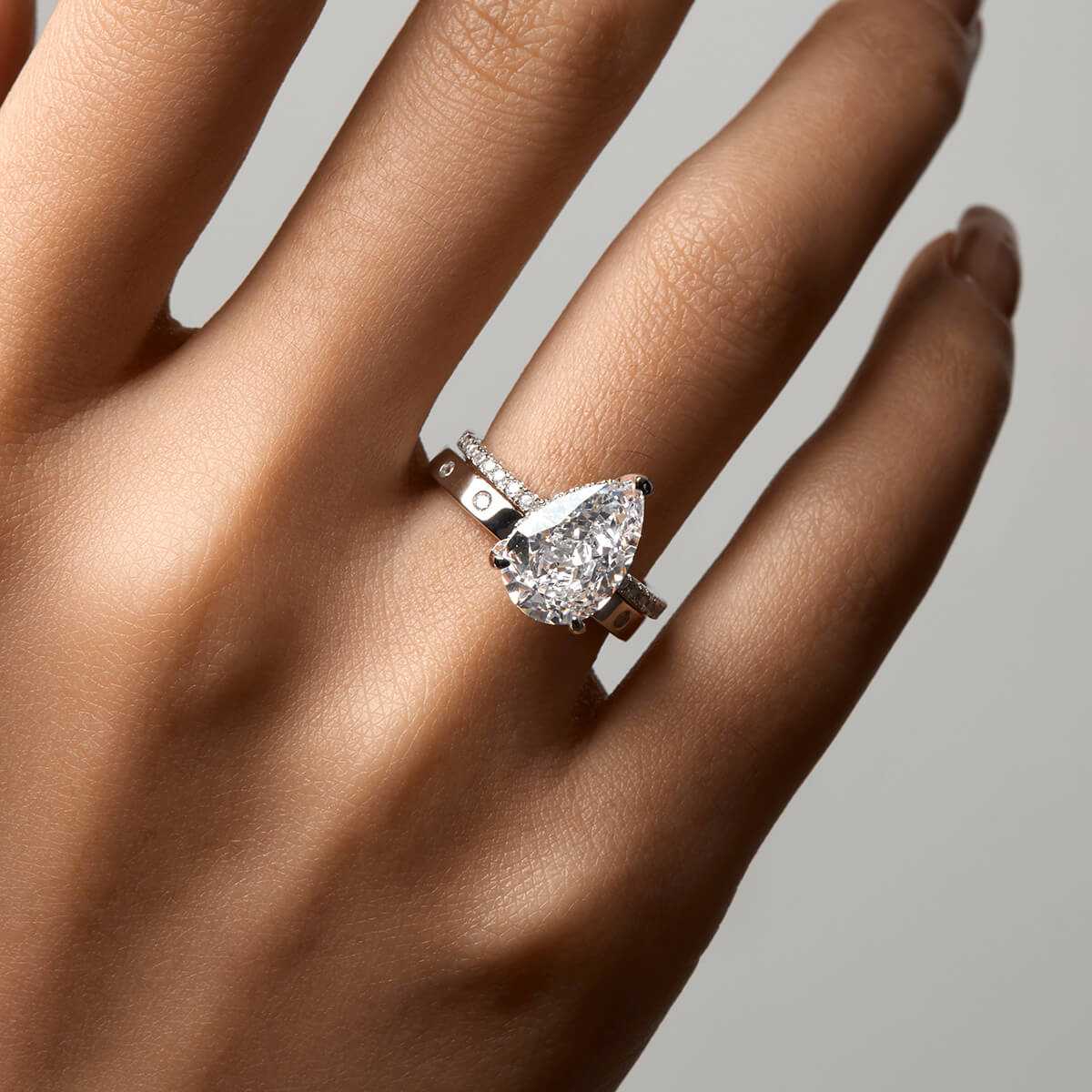 Kylariel pear-shaped moissanite solitaire engagement ring with half pavé and hidden halo on hand