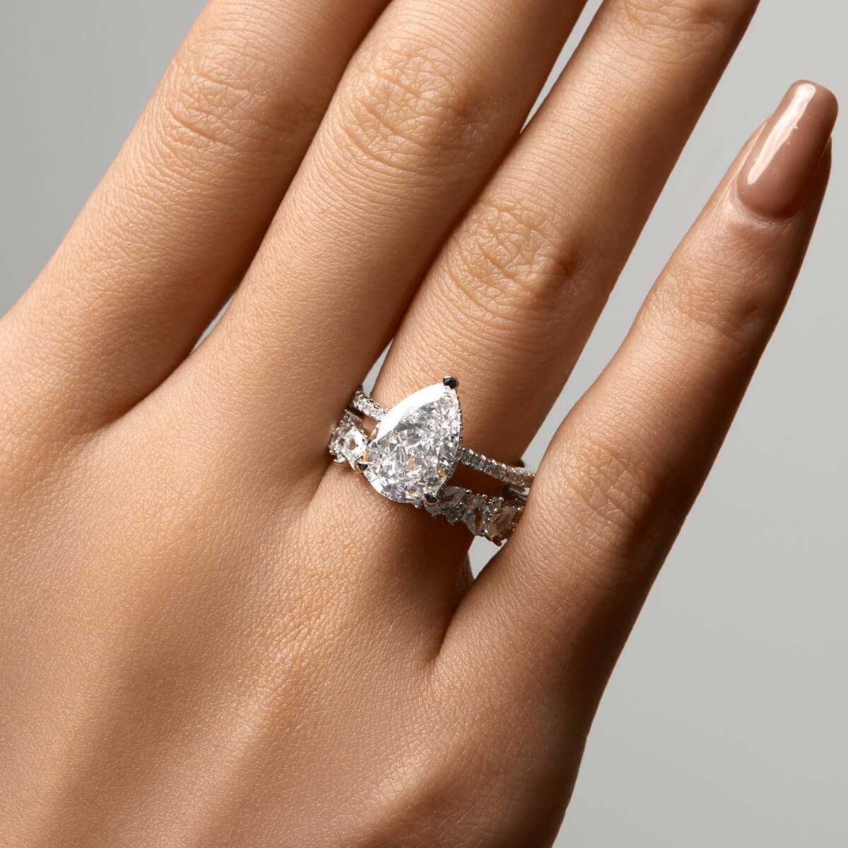 Kylariel solitaire engagement ring with pear-shaped moissanite and half pavé design on hand