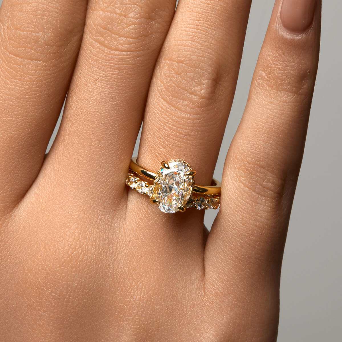 Nolindra solitaire engagement ring with oval Moissanite and pavé hidden halo on hand