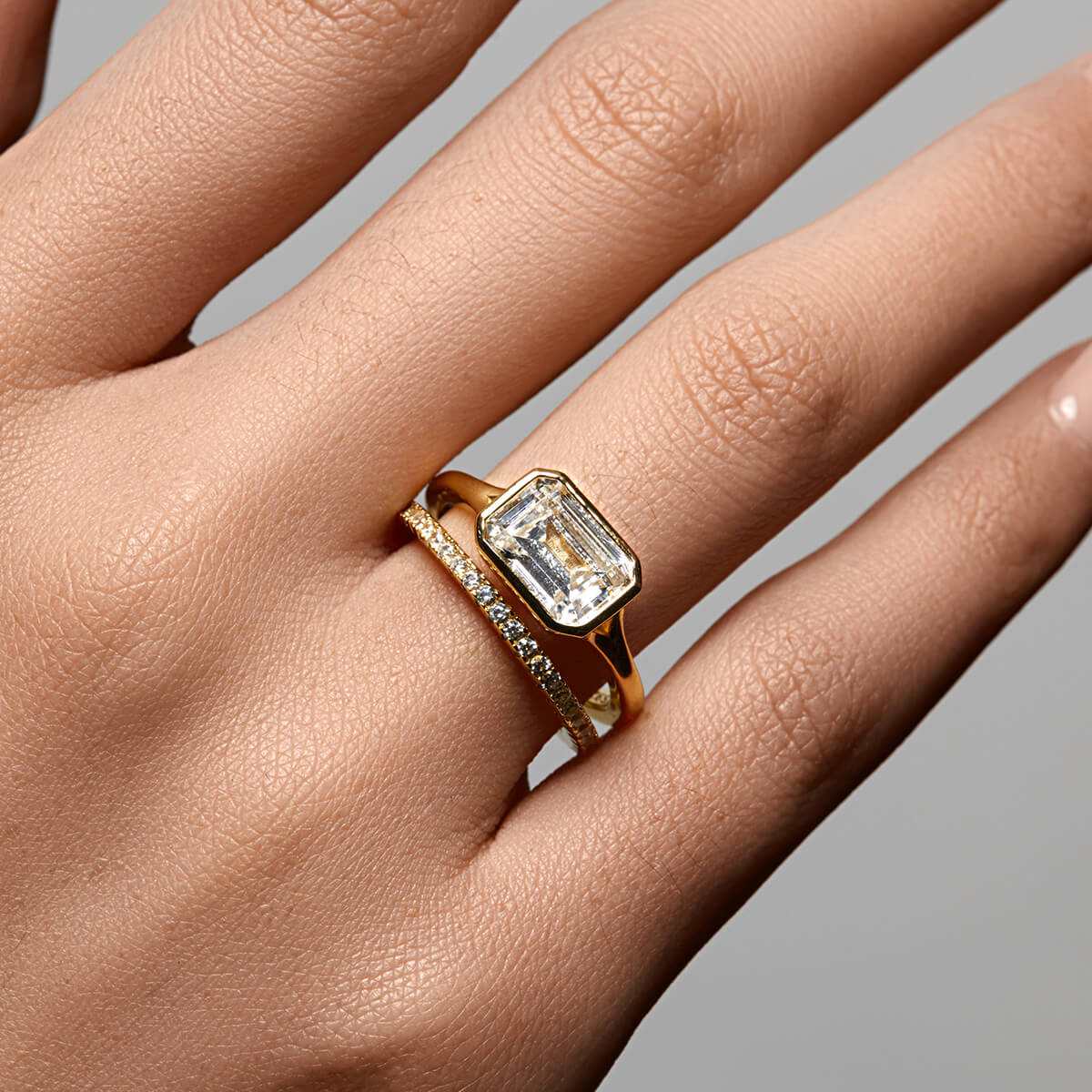 Roen Ring Damariel with east-west emerald moissanite solitaire and split shank design on hand