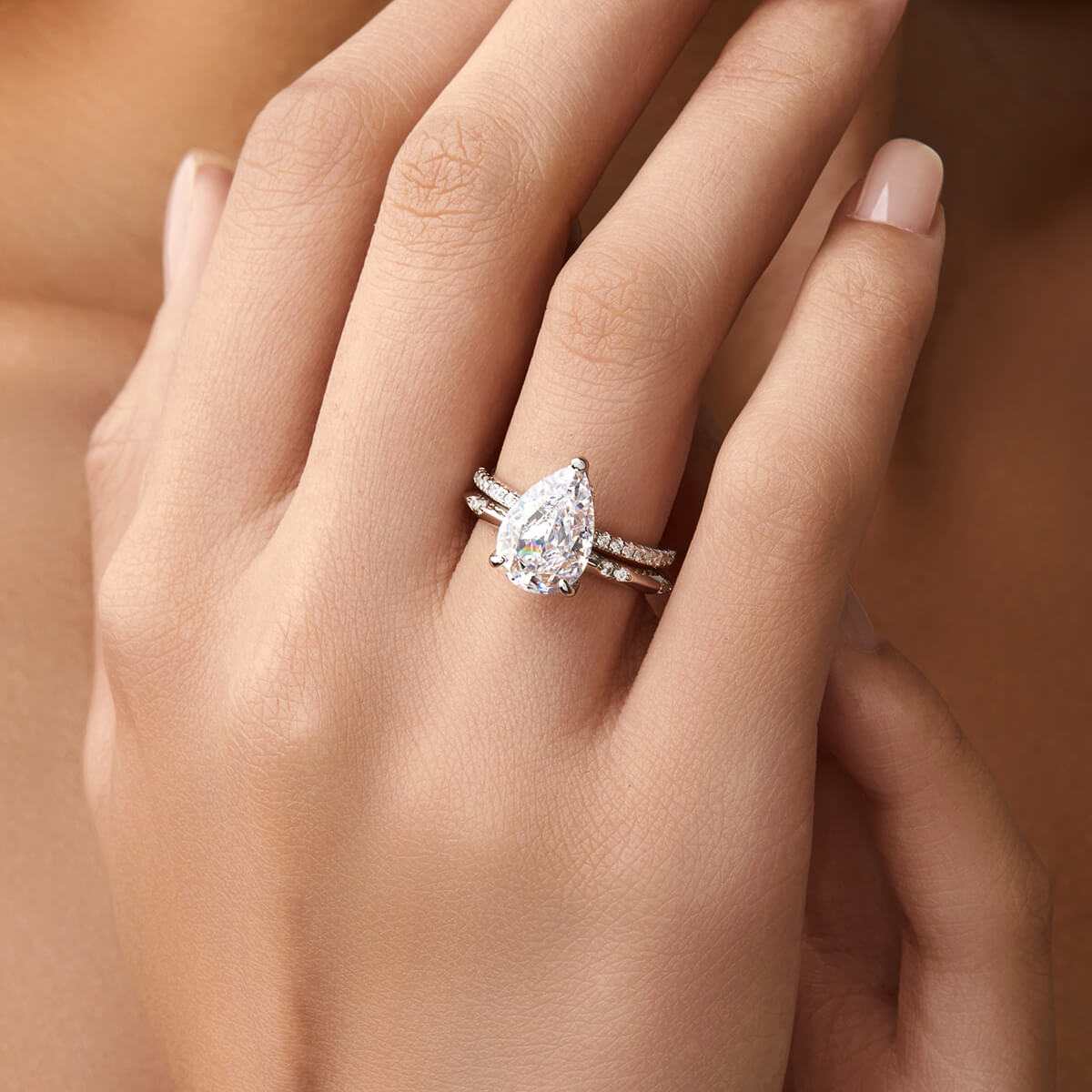 Kylariel pear-shaped moissanite solitaire engagement ring with half pavé and hidden halo on hand