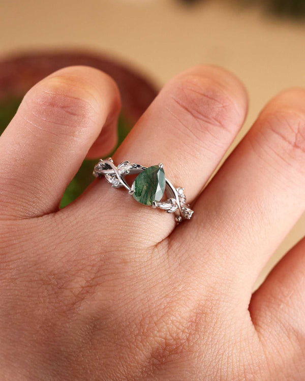 Quistwen solitaire engagement ring with pear-shaped moss agate and moissanite on split shank band with leaf motif