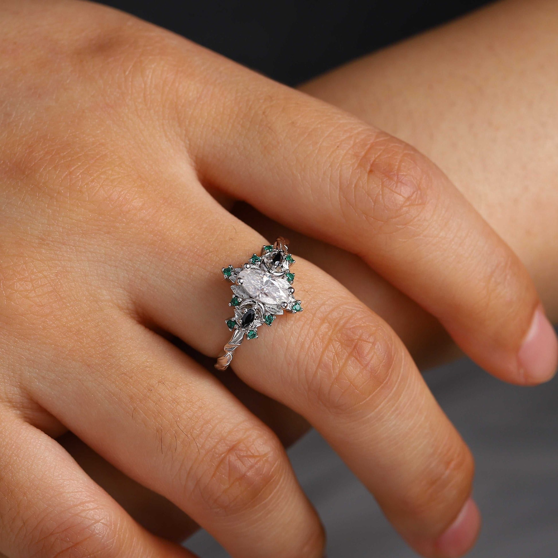Wynriel three-stone engagement ring with marquise moissanite center and green gemstone accents on hand