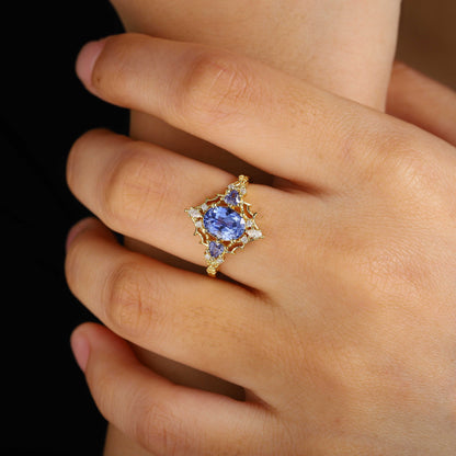 Corsaviel three-stone engagement ring with oval sapphire and gold band on hand
