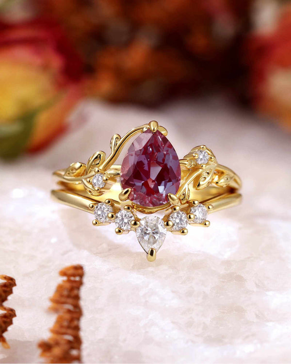 gold pear-shaped Alexandrite ring with diamond accents and leaf vine motif band