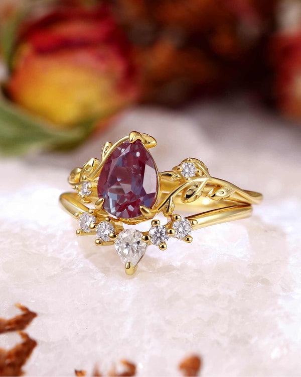 pear-shaped Alexandrite ring with Moissanite side stones and leaf vine gold band