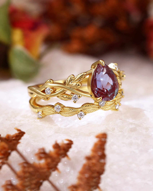 Dorelith pear-shaped Alexandrite ring with moissanite stones and leafy gold band