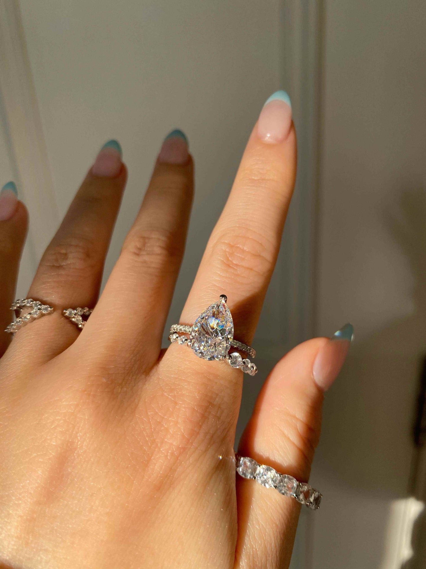 Kylariel pear-shaped moissanite engagement ring with half pavé and hidden halo on hand