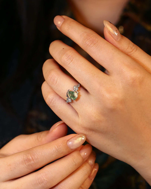 Pear-shaped Moss Agate engagement ring with leaf-inspired shank and Moissanite accents on hand