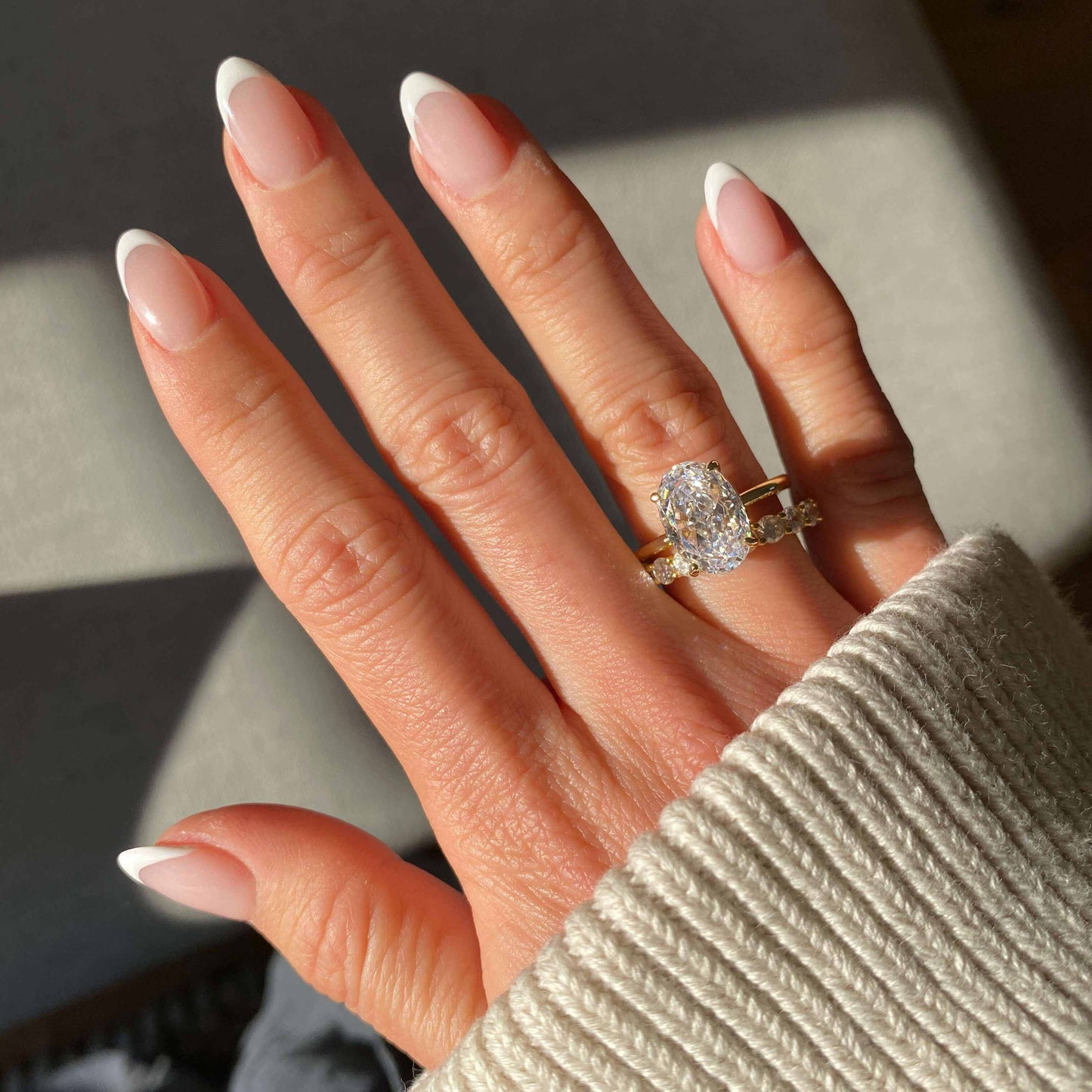 Close-up of hand wearing Pherinwen Deus Ring with oval-cut 3-carat moissanite and crushed ice effect solitaire design