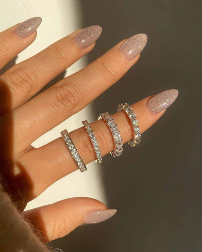 Hand wearing Perawen Selene eternity ring with round moissanite stones sparkling around the band