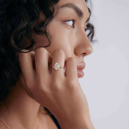 Nolindra solitaire engagement ring with oval Moissanite and pavé hidden halo on model's hand