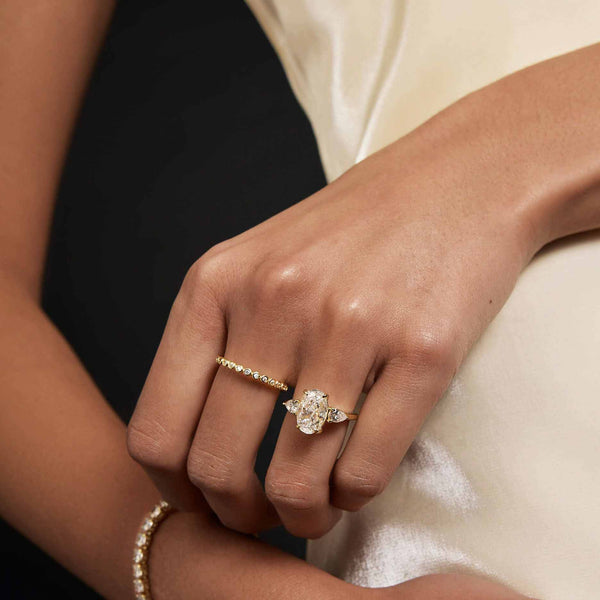 Heloriel engagement ring with oval moissanite center and pear-shaped side stones on hand