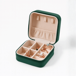 Green leather travel case with beige interior, compartments for jewelry storage