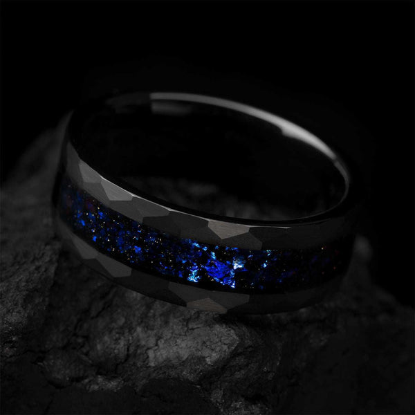 Dianviel 8mm eternity wedding band with faceted black design and blue alexandrite inlay on rock background