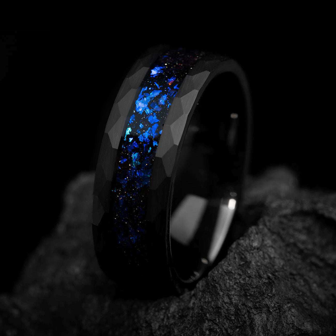 Dianviel 8mm black eternity wedding band with sparkling alexandrite center and faceted design on dark stone background