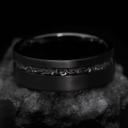 Yiloria black ring with genuine meteorite inlay and eternity design on textured stone background