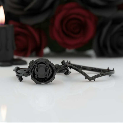 Koraviel black moissanite ring with sleek modern design and thorn-like band against a background of red roses and black candle