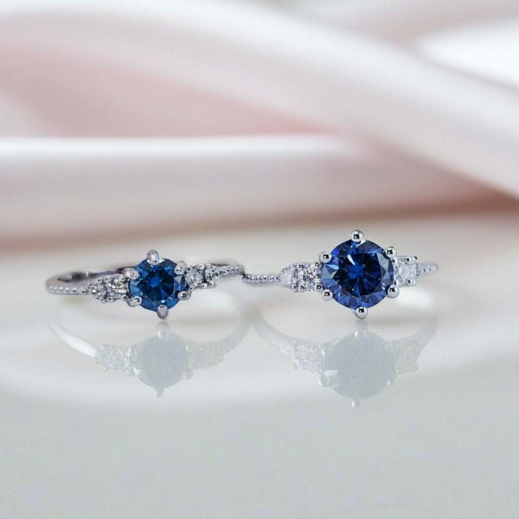Gloraviel three-stone engagement ring with blue center stones and side diamonds in silver setting
