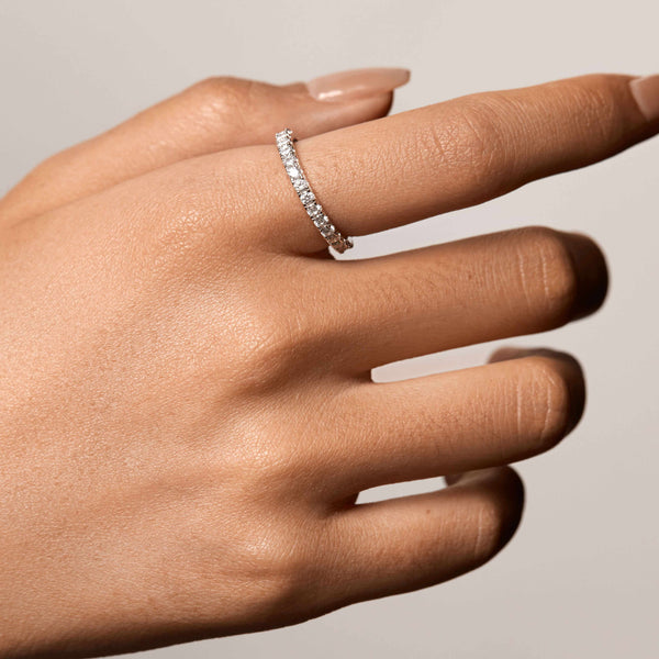 Selene eternity ring with petite round moissanite stones on finger